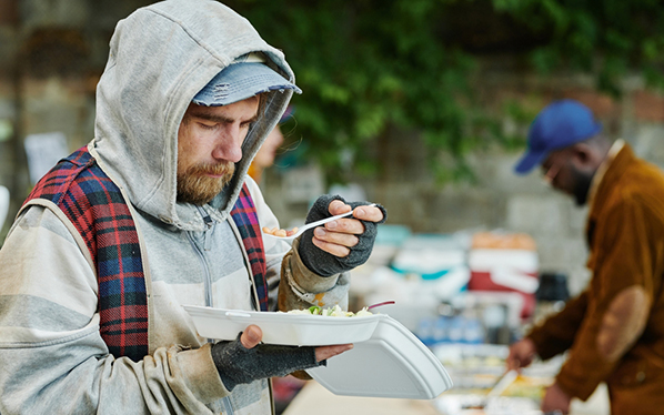 Homeless man eating charity food
